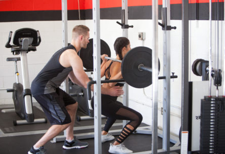 woman lifting heavy weights while strength training