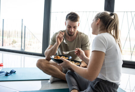 man and woman eating healthy meal after personal training and group fitness